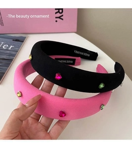 Detail of pink and black sponge headbands with colorful heart crystals and fabric texture