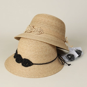 Detailed texture of raffia sun hats with woven flowers and detachable chin straps