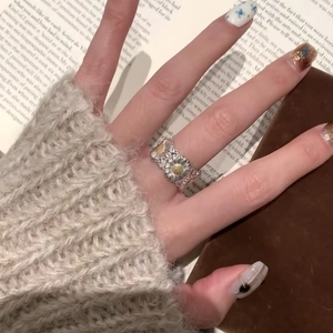 Exquisite silver daisy flower open ring with gold pistils worn in a lifestyle setting