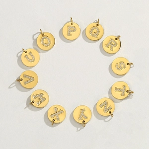 Close-up of gold 14K plated round pendants with sparkling rhinestones letters O to Z