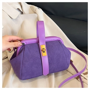 Detail showing purple suede and leather contrast textures on shell-shaped handbag