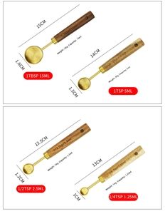 Detail of four gold-plated stainless steel measuring spoons with walnut wooden handles