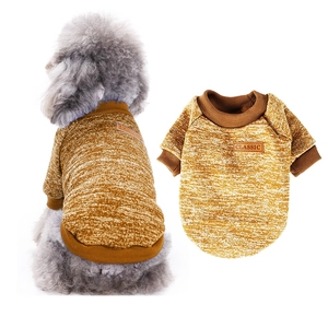 Detail showing ginger yellow knit puppy sweater with classic leather patch and ribbed cuffs