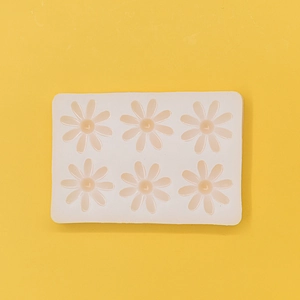 Detail of 6-cavity white silicone mold with daisy flower shapes for DIY chocolate and soap