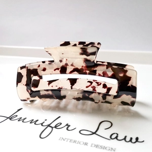 Detail view of large rectangular hollow hair claw with cream and brown tortoiseshell pattern