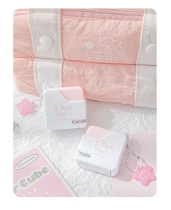 Close-up of portable pink and white mini stapler with cute star pendant on white paper