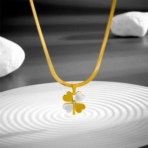 Collier trèfle minimaliste doré avec pétales sablés sur un fond blanc élégant
