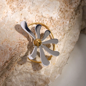 Detailed macro of abstract two-tone flower earrings on natural stone surface