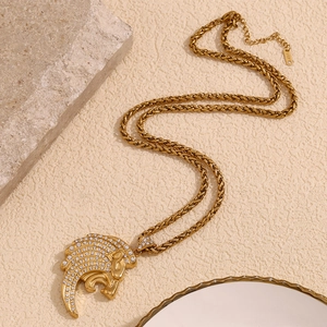 Détail d'un pendentif tête de lion hip hop serti de zircons sur une chaîne tressée en or 18K