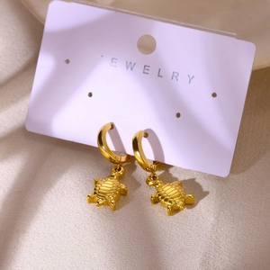 Gros plan de boucles d'oreilles tortue dorée sur carte bijoux avec style plage