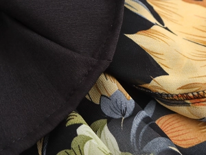 Dettaglio del tessuto in chiffon floreale e cuciture di qualità sull'abito con scollo a v