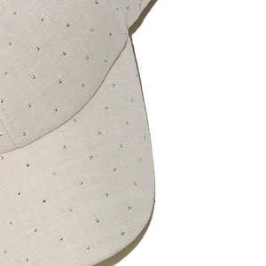 Vue macro de strass étincelants sur le tissu en sergé beige de la casquette de baseball