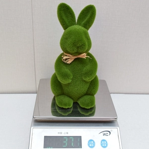 Detailed view showing the lightweight 37.1g mass of the green flocked moss Easter rabbit