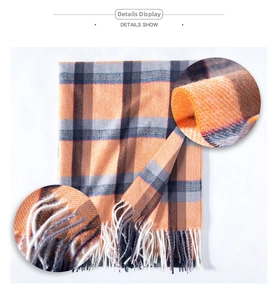 Detail view of plaid cashmere-like scarf showing fabric texture and tassel trim
