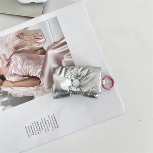 Detail of silver puffy bow protective case with pink hook on fashion magazine background