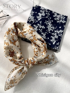 Detail of two floral cotton linen scarves in yellow and navy with rustic aesthetic
