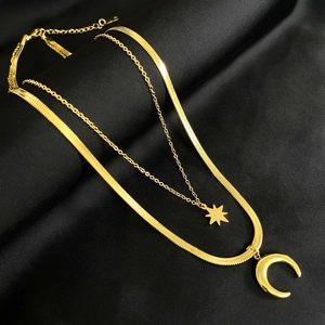 Detail shot of 18K gold plated double layer necklace with star and moon pendants