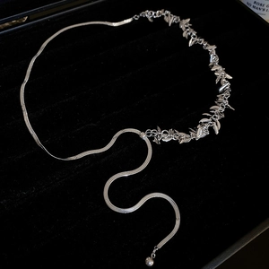Silver leaf tassel choker necklace displayed on black velvet inside a luxury jewelry box
