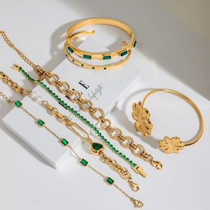 Dettaglio del set di gioielli placcati in oro con zirconi verde smeraldo e ciondoli a cuore