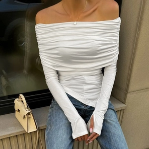 Close-up of elegant white off-shoulder top with detailed pleated fabric and slim fit