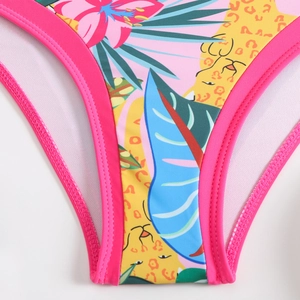 Detailed close-up of vibrant tropical floral and leopard print on stretch bikini fabric