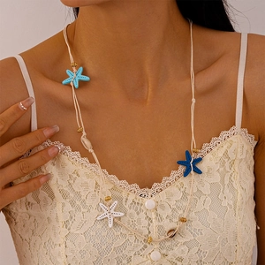 Detail of beach style long necklace with blue starfish pendants and natural shells