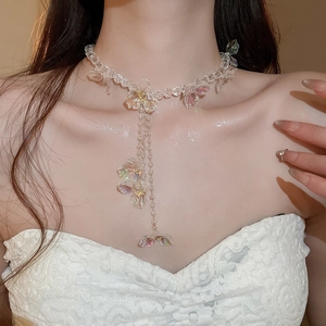 Detail of floral crystal necklace featuring elegant long tassel pendant on model neck