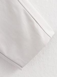 Detailed close-up of single needle stitching on light gray woven bomber jacket fabric