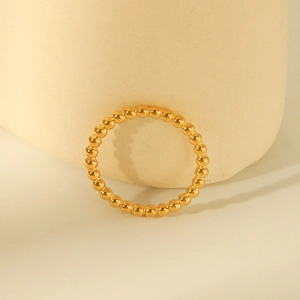 Elegant gold titanium steel beaded ring with minimalist design on textured stone base