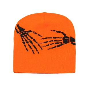 Gros plan du bonnet en tricot orange avec motif imprimé de mains de squelette noir