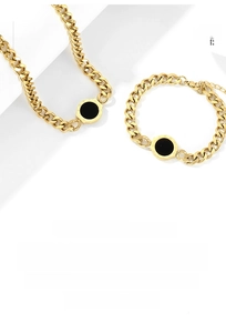 Detailed macro view of gold-plated Roman numeral pendants on a necklace and bracelet set
