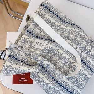 Detail of floral canvas tote bag with Animal Patterns label and blue wave patterns