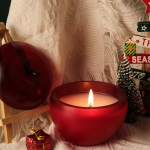 Vue macro d'un bougeoir en forme de pomme rouge mat avec une flamme allumée