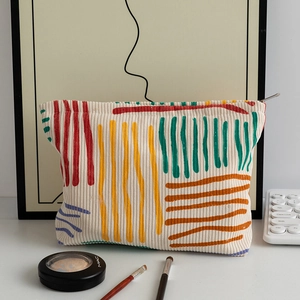 Detailed texture of floral corduroy makeup bag with colorful hand-painted stripes
