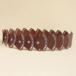 Dettaglio della cintura larga in pelle marrone con occhielli metallici e rivetti decorativi