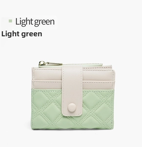 Detail of light green and beige patchwork wallet with classic quilted stitching design