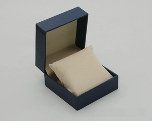 Detail of navy blue textured leather watch box with a soft beige interior cushion