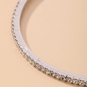 Macro shot of silver metal hoop earrings with continuous clear rhinestones in a luxury style