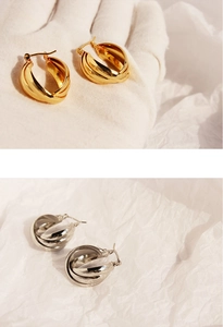 Macro detail of multilayer twisted metal earrings in gold and silver finishes