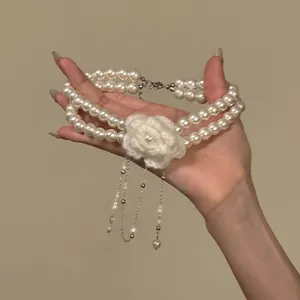 Elegant double layer pearl necklace with knitted flower charm and silver tassels