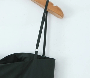 Close-up of thin shoulder straps and neckline on a black backless dress