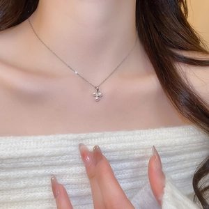 Close-up of elegant silver necklace with pearl flower pendant worn by a model