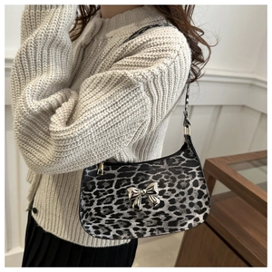 Close-up of leopard print baguette bag featuring a silver metal bow and zip closure