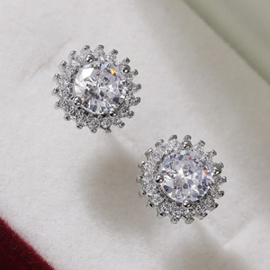 Macro shot of silver sunflower stud earrings with large round zircon and halo detail