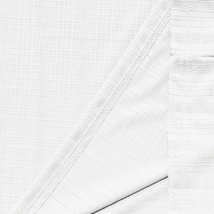 Close-up of white breathable waffle knit fabric showing premium stitching and texture