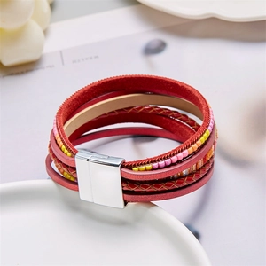 Détail d'un bracelet multicouche en cuir rouge bohème avec perles et fermoir magnétique