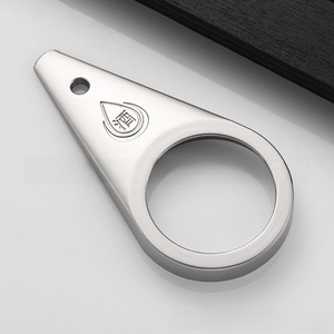 Macro view of silver matte teardrop-shaped metal bottle opener with engraved character