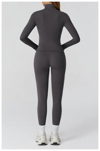 Rear view of slim fit dark gray yoga set featuring zip-up jacket and high waist leggings