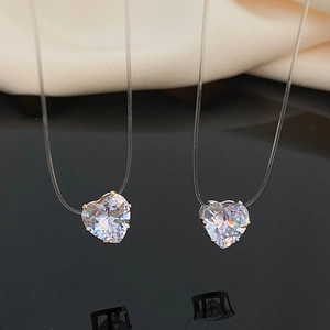 Invisible fishing line necklace with floating heart-shaped zircon pendant on black surface