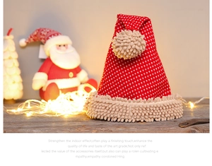 Close-up of a festive red knitted Christmas hat with warm LED holiday background